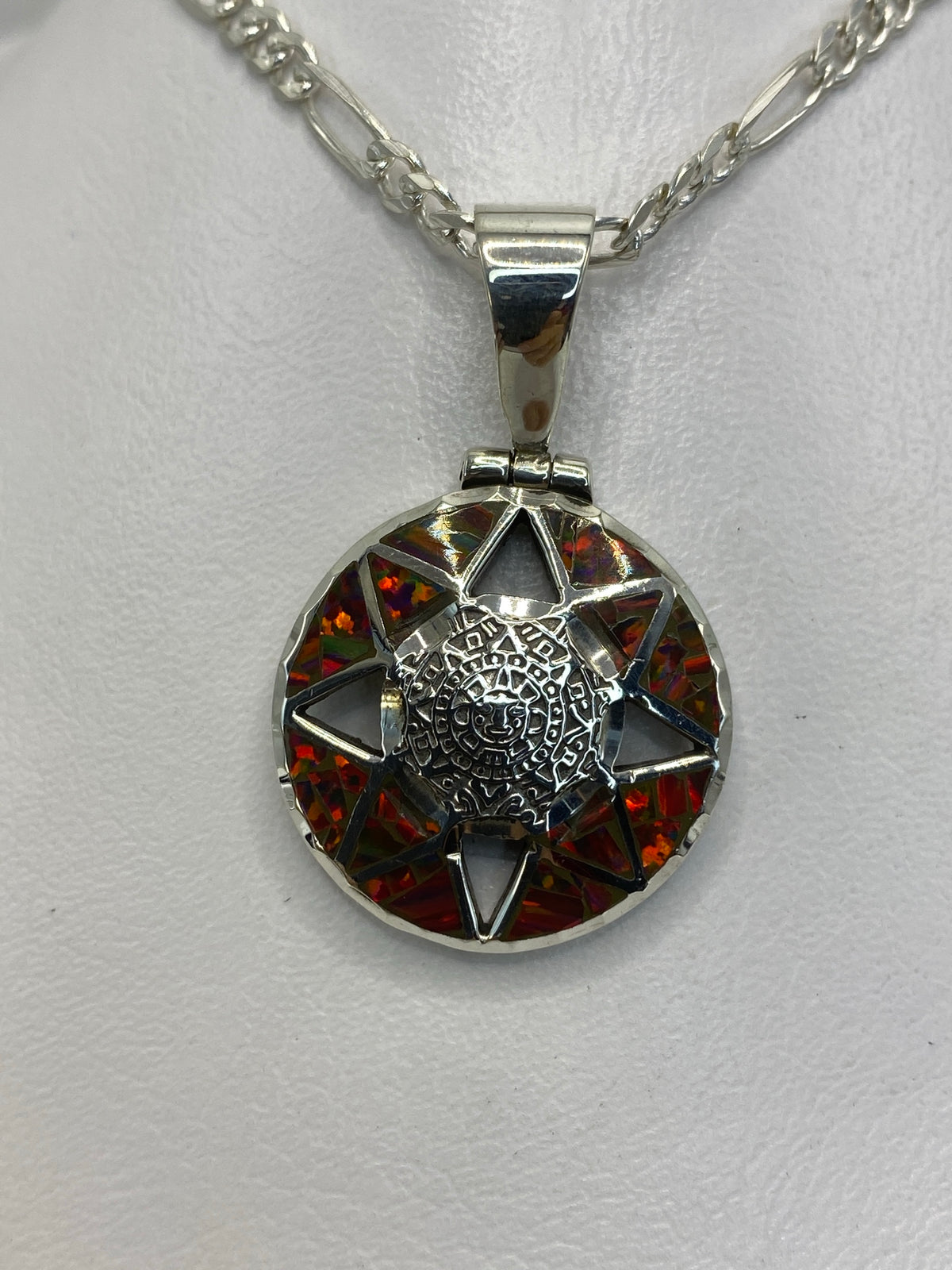 Dije de plata 950 con ópalo de fuego multicolor y diseño prehispánico labrado, suspendido en cadena plateada