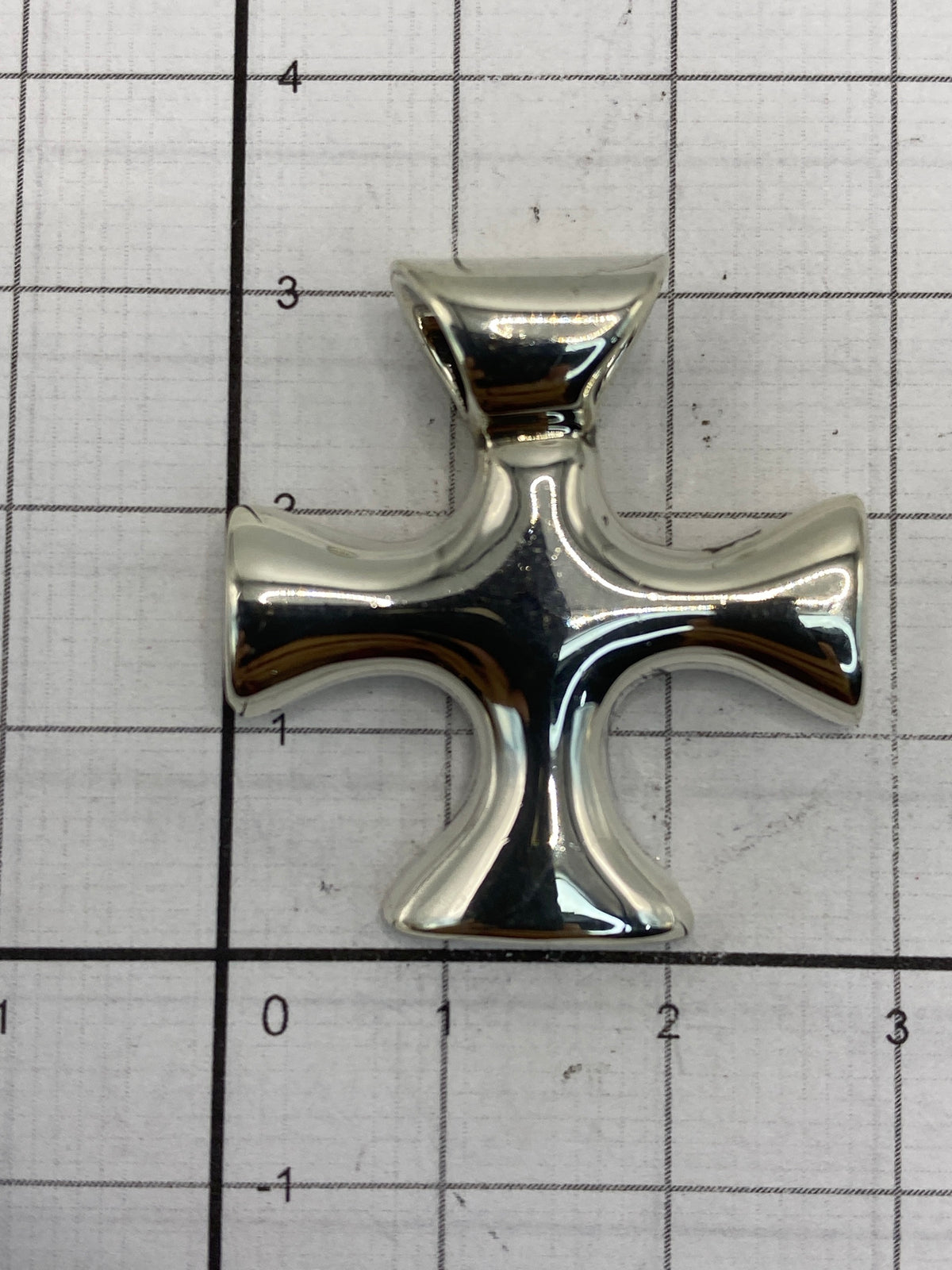 Cruz de plata de Taxco midiendo 3 × 2.5 cm en escala