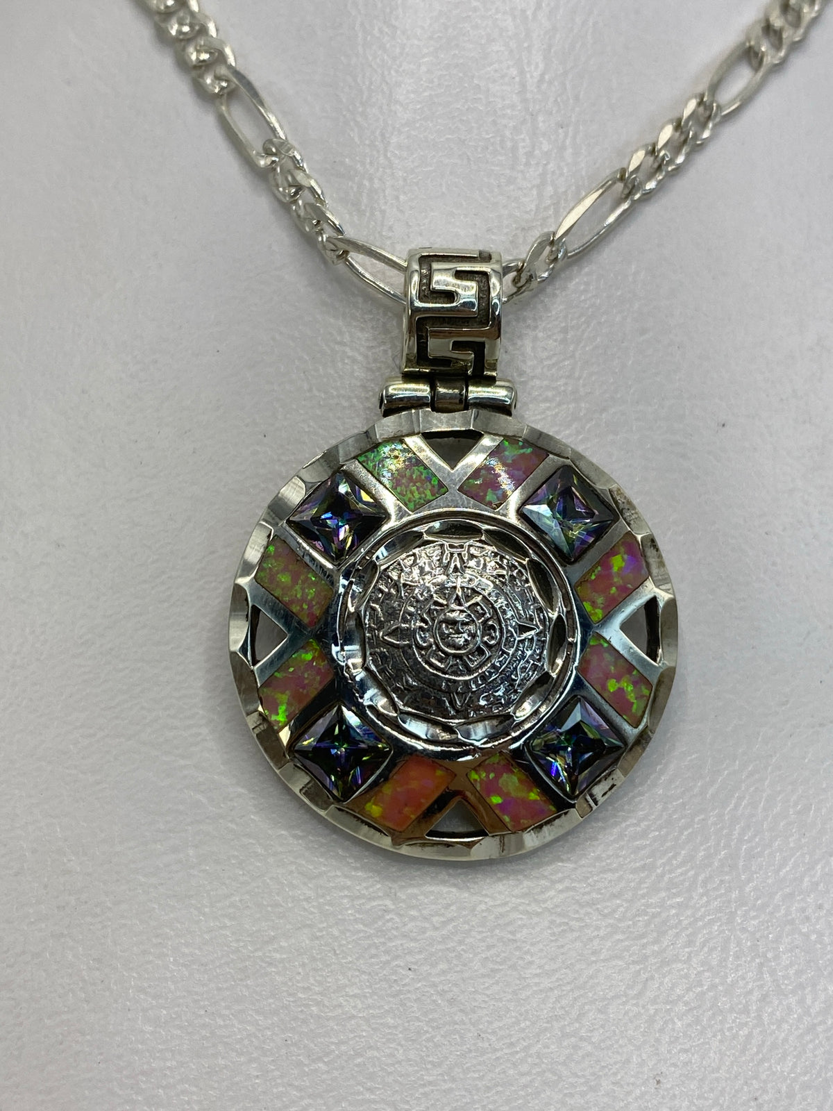 Dije de plata 950 con ópalo de fuego rosa y calendario azteca, sobre cadena figaro