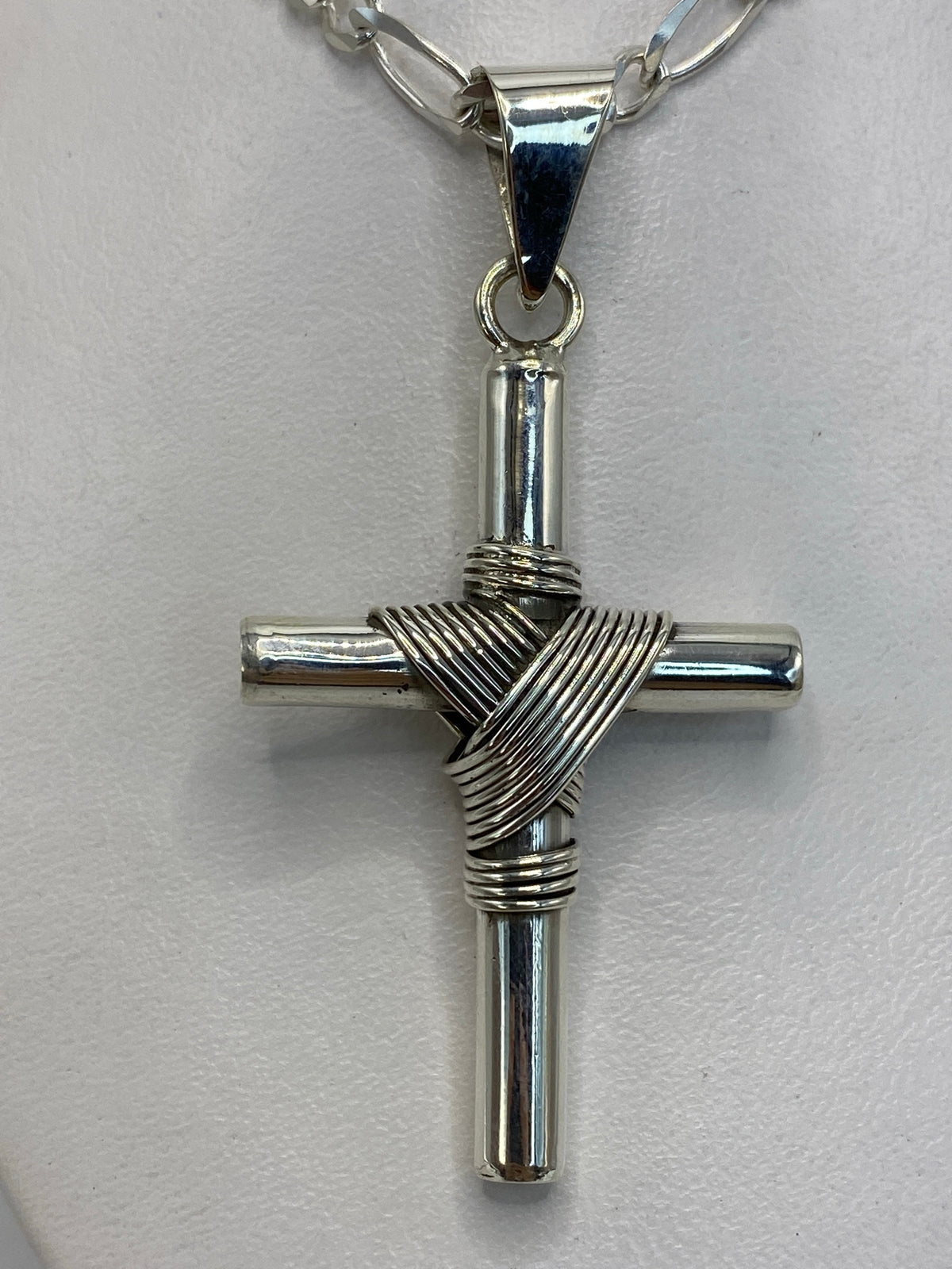 Dije cruz de plata junto a regla métrica: 6 cm de largo × 3 cm de ancho