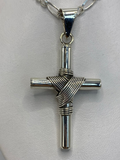 Dije cruz de plata junto a regla métrica: 6 cm de largo × 3 cm de ancho