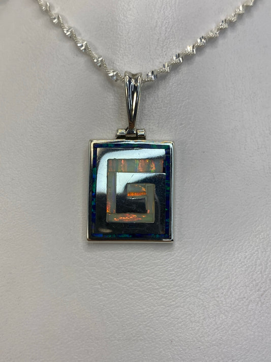 Dije de plata 950 con ópalo de fuego blanco en diseño geométrico cuadrado, colgado en cadena de plata