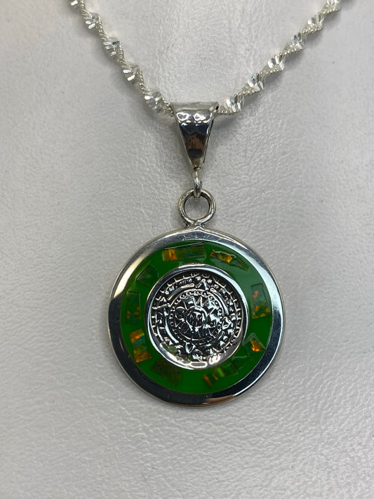 Dije de plata 925 con ópalo de fuego verde en la mano, sobre fondo blanco