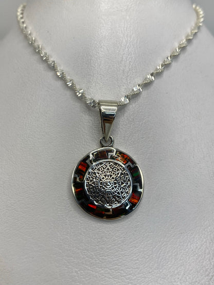 Detalle del mandala prehispánico grabado en plata 950 con ópalo de fuego en el centro