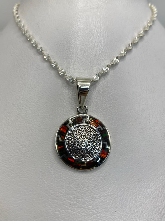 Detalle del mandala prehispánico grabado en plata 950 con ópalo de fuego en el centro