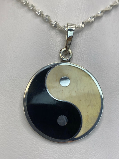 Medidas del dije yin-yang: 4 cm de largo × 2.7 cm de ancho sobre regla