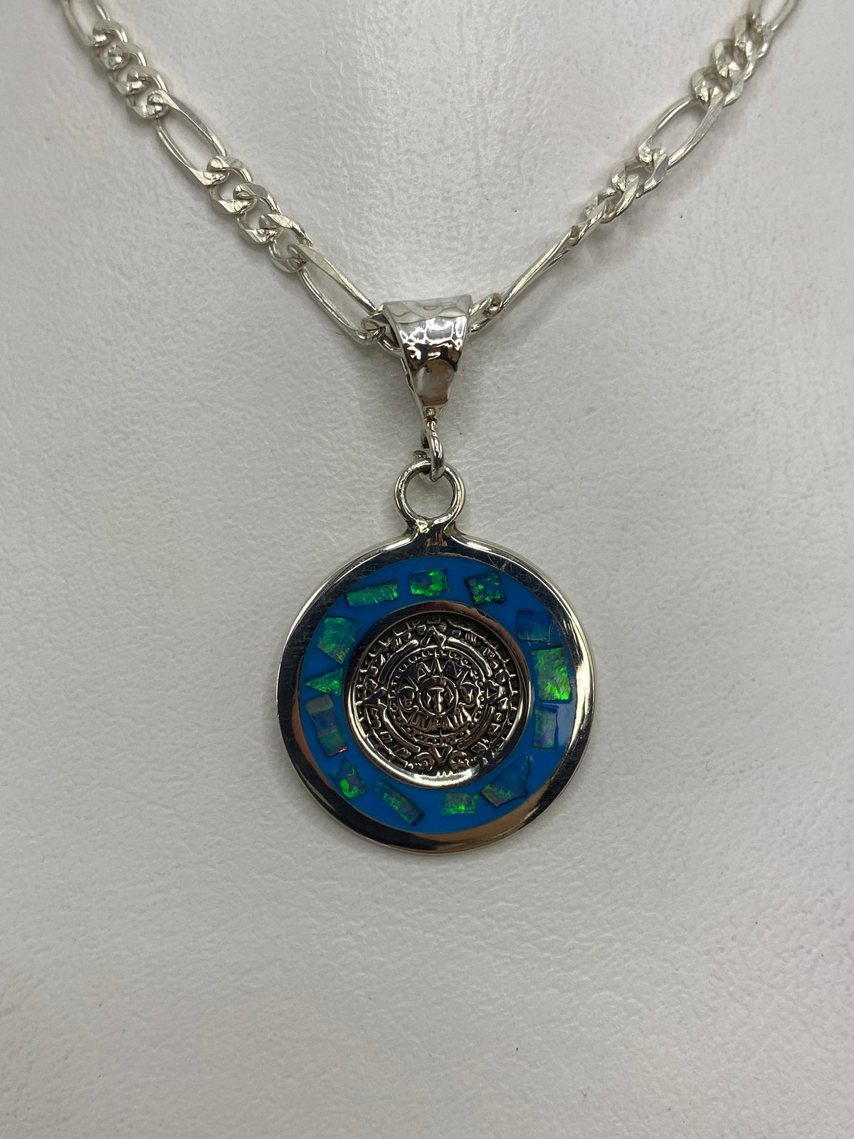 Detalle frontal del Calendario Azteca en relieve con ópalo azul incrustado en periferia
