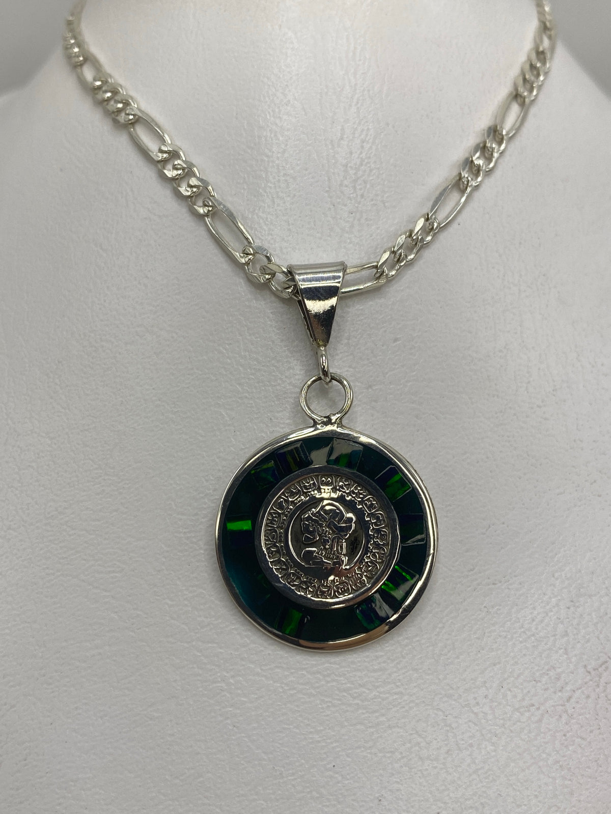 Detalle del dije prehispánico: relieves del calendario azteca en plata y ópalo verde engastado