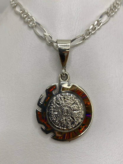 Detalle frontal del dije Piedra del Sol con ópalo de fuego rodeando el diseño grabado