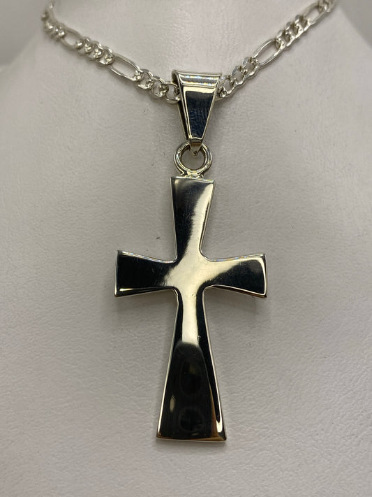 Dije cruz de plata 925 de Taxco con lados biselados, colgando de cadena figaro