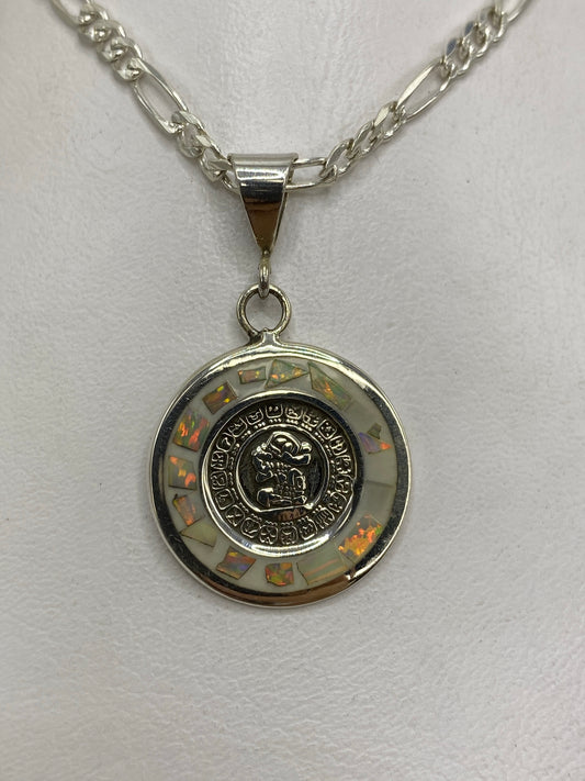 Dije de plata con calendario azteca y ópalo de fuego blanco, colgado en cadena plateada