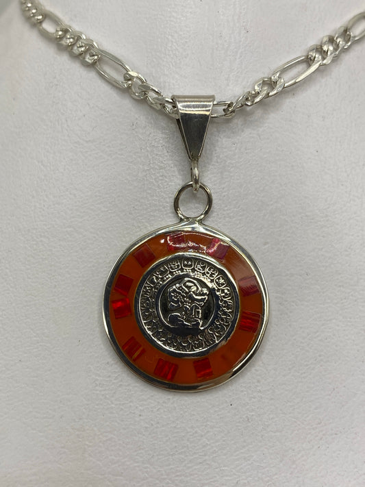Dije de plata con ópalo de fuego rojo en diseño prehispánico, colgado de una cadena figaro de plata