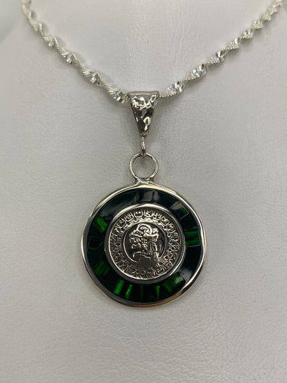 Detalle del calendario azteca grabado en el dije de plata, con ópalo verde engastado en el centro