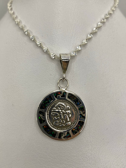 Detalle frontal del dije mostrando el ópalo multicolor (azul, verde, naranja) en engaste de plata
