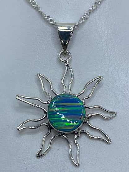 Dije de plata 925 en forma de sol con ópalo de fuego azul en el centro