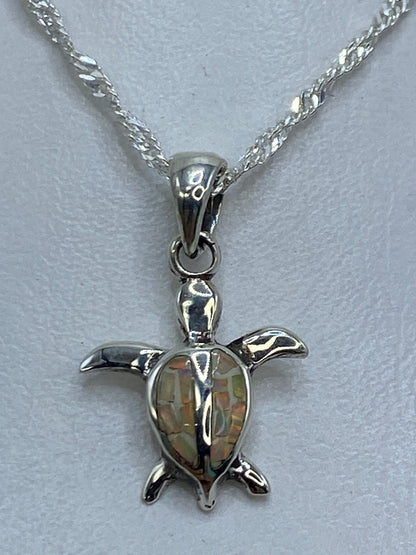 Dije tortuga de plata 950 con ópalo de fuego multicolor colgado de cadena plateada