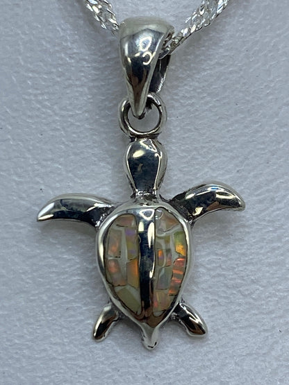 Vista frontal del dije tortuga de plata pura de Taxco, 2 cm de largo