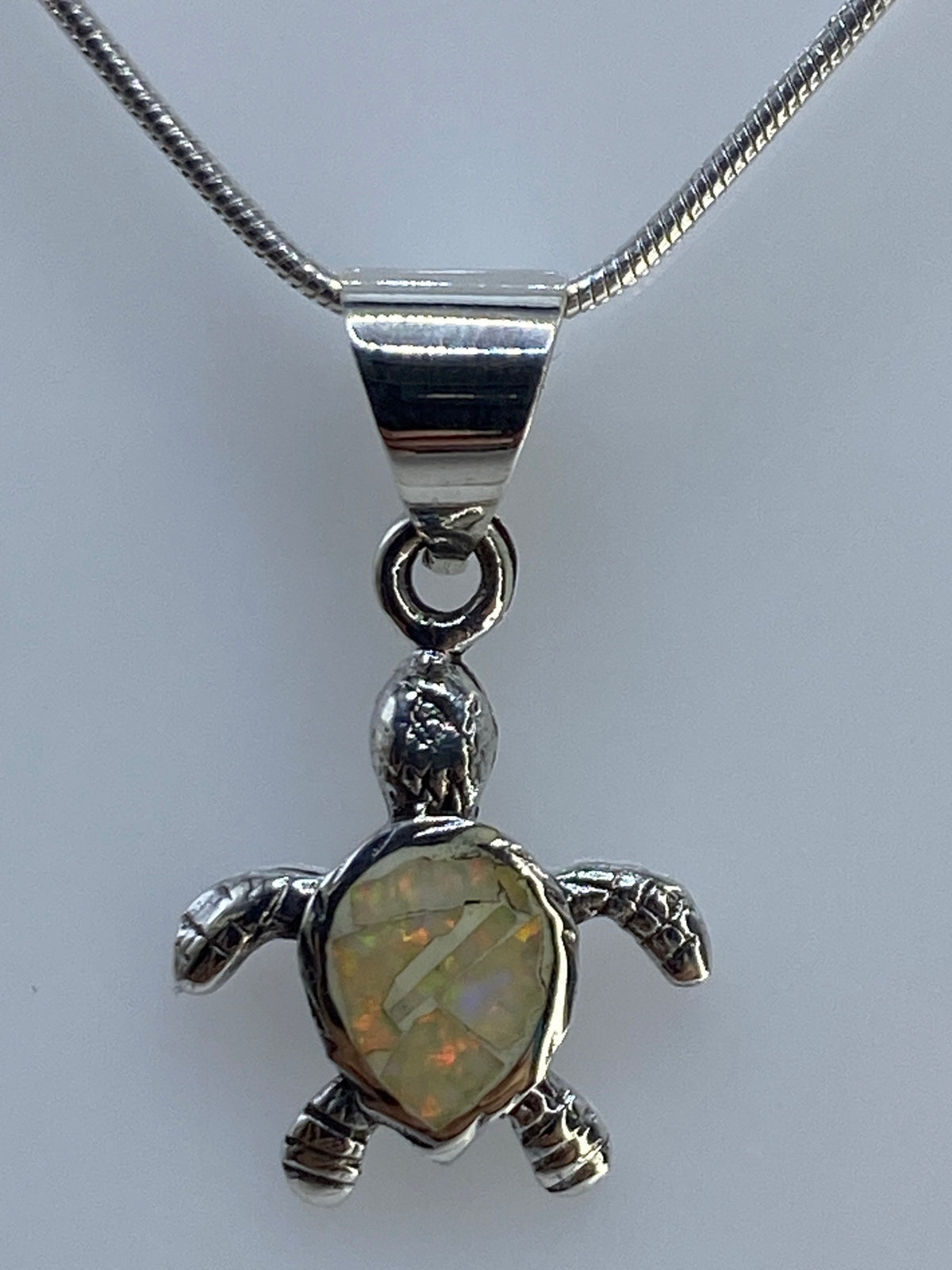 Dije de plata con opalo de fuego multicolor, 2 cm de largo, engastado a mano
