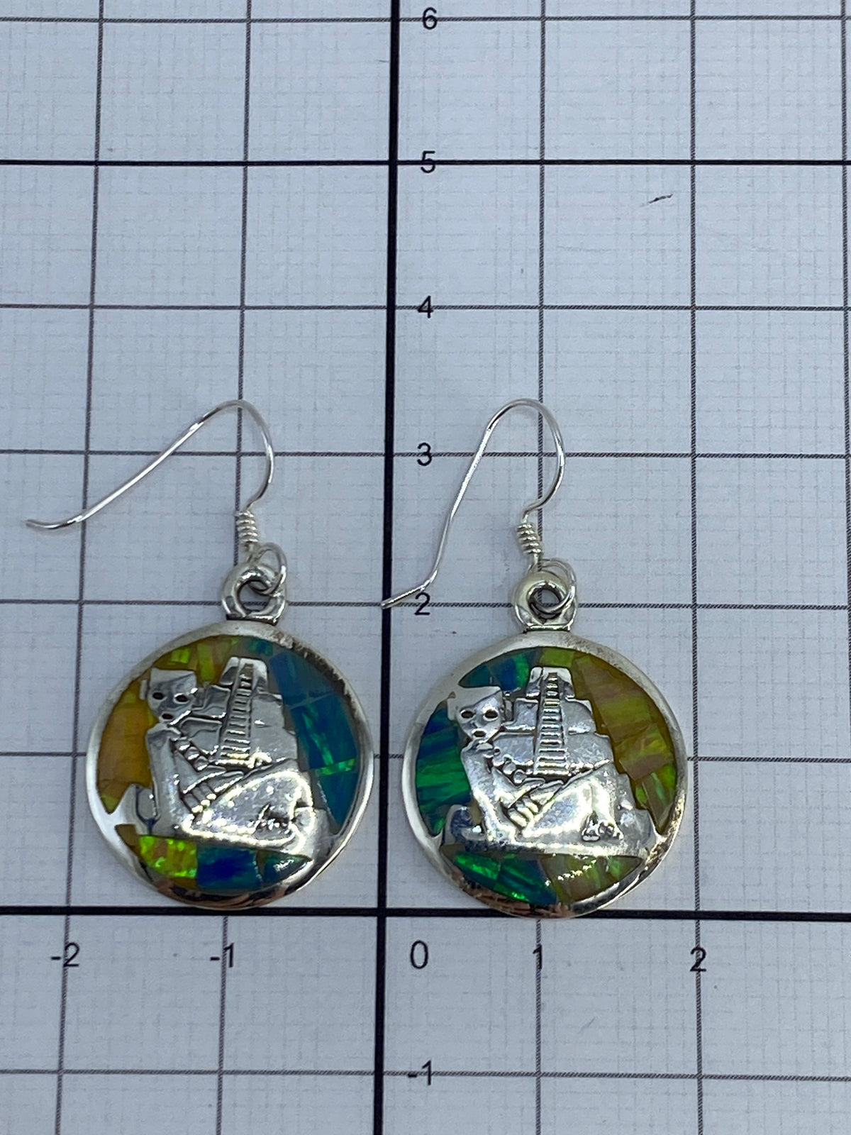 Aretes de ópalo de fuego colgando, capturando la luz en los tonos multicolor de la piedra