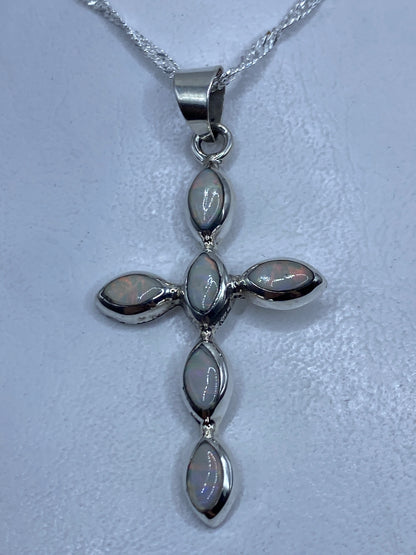 Dije cruz de plata .950 con ópalos de fuego multicolor, colgando de una cadena