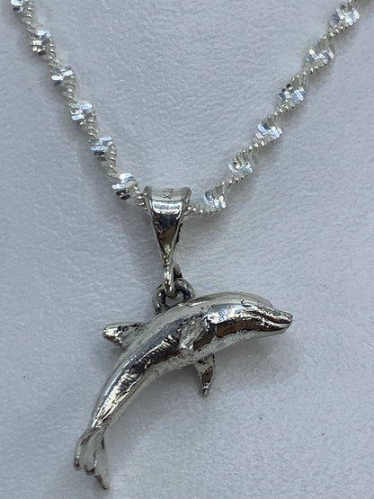 Dije de delfín en plata .925 de Taxco, saltando hacia adelante, colgado en cadena decorativa de plata