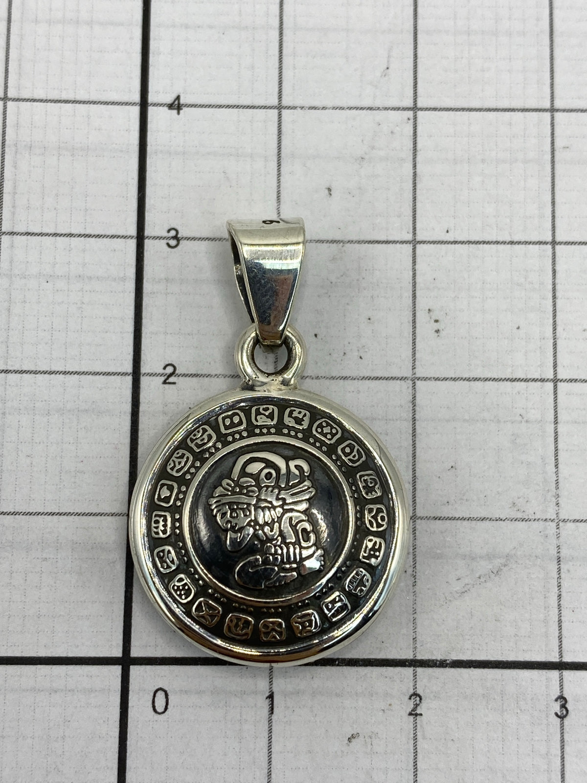 Comparación de tamaño del dije (2.8 cm) sobre una regla de centímetros