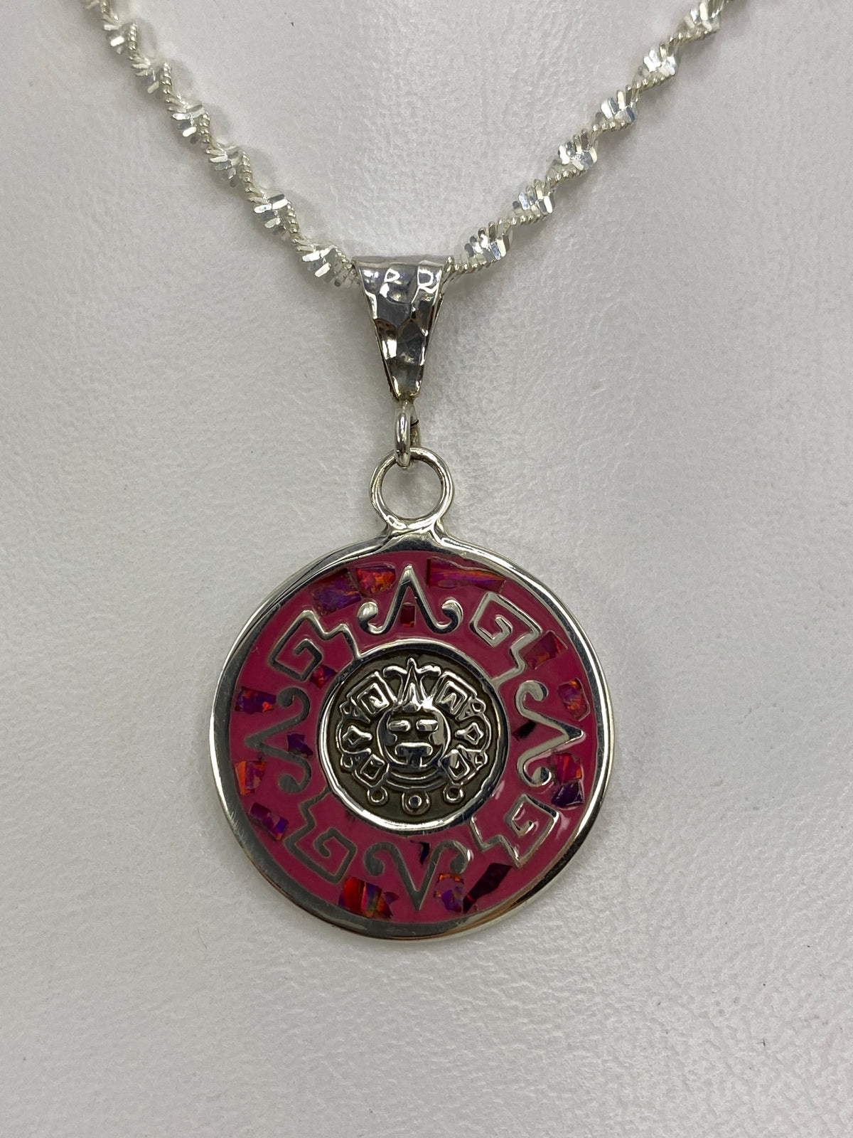 Dije de plata 925 con ópalo de fuego rosa y diseño prehispánico de sol central rodeado de grecas