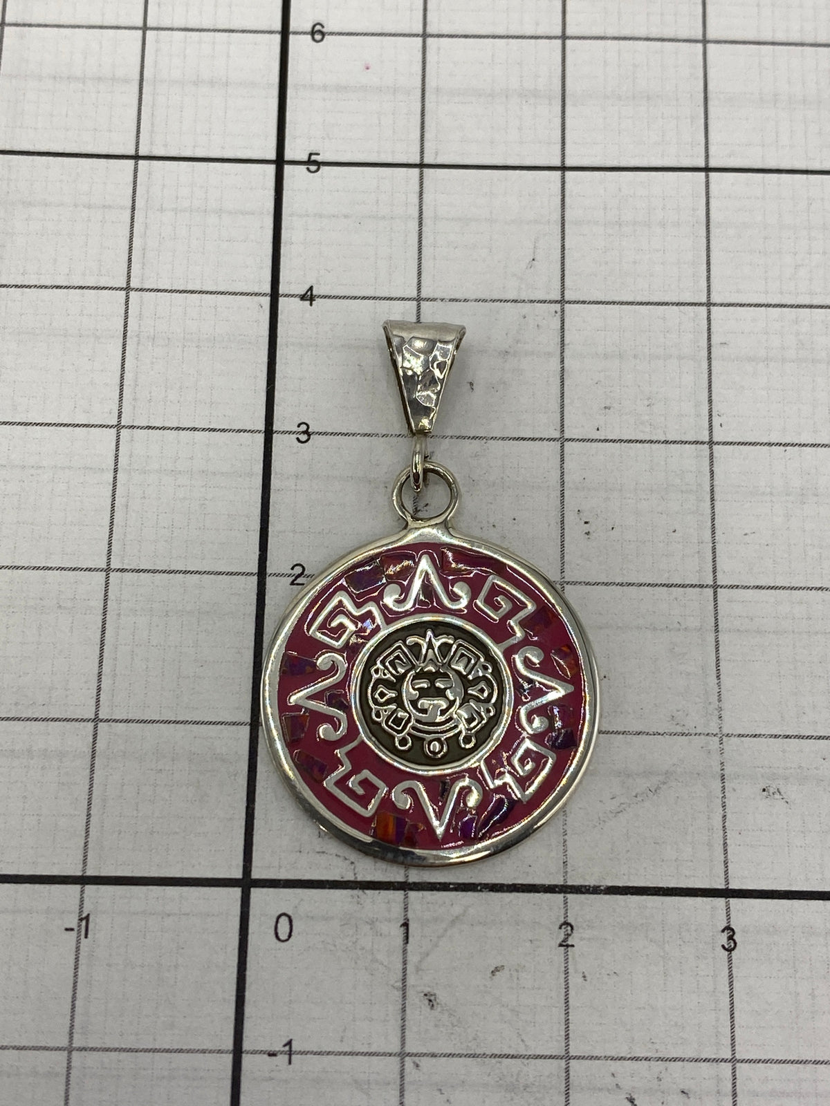 Medición del dije en escala milimétrica: 4.8 cm de largo × 2.2 cm de ancho