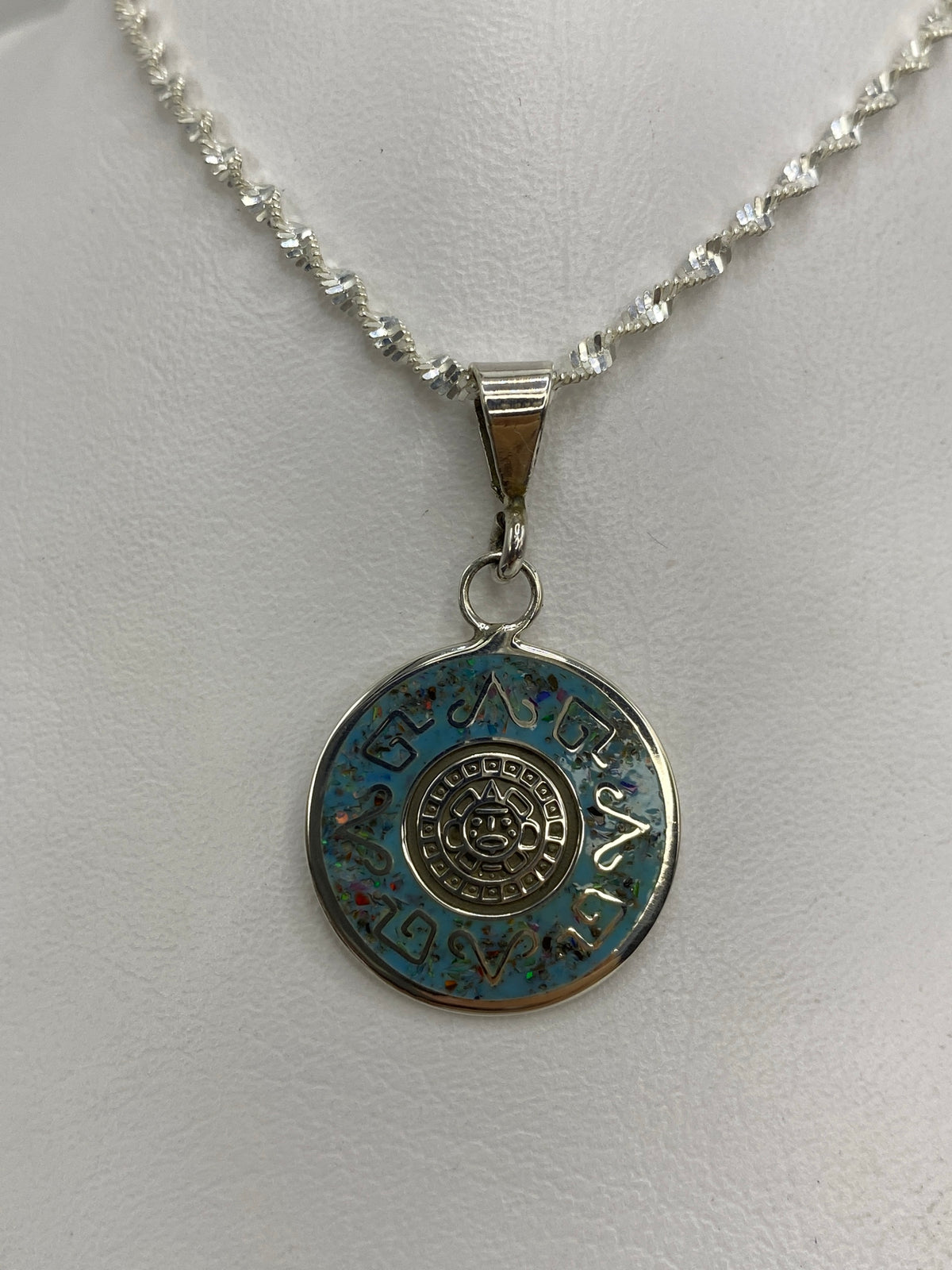 Detalle del Ollin (símbolo azteca de movimiento) rodeado de glifos en plata 925