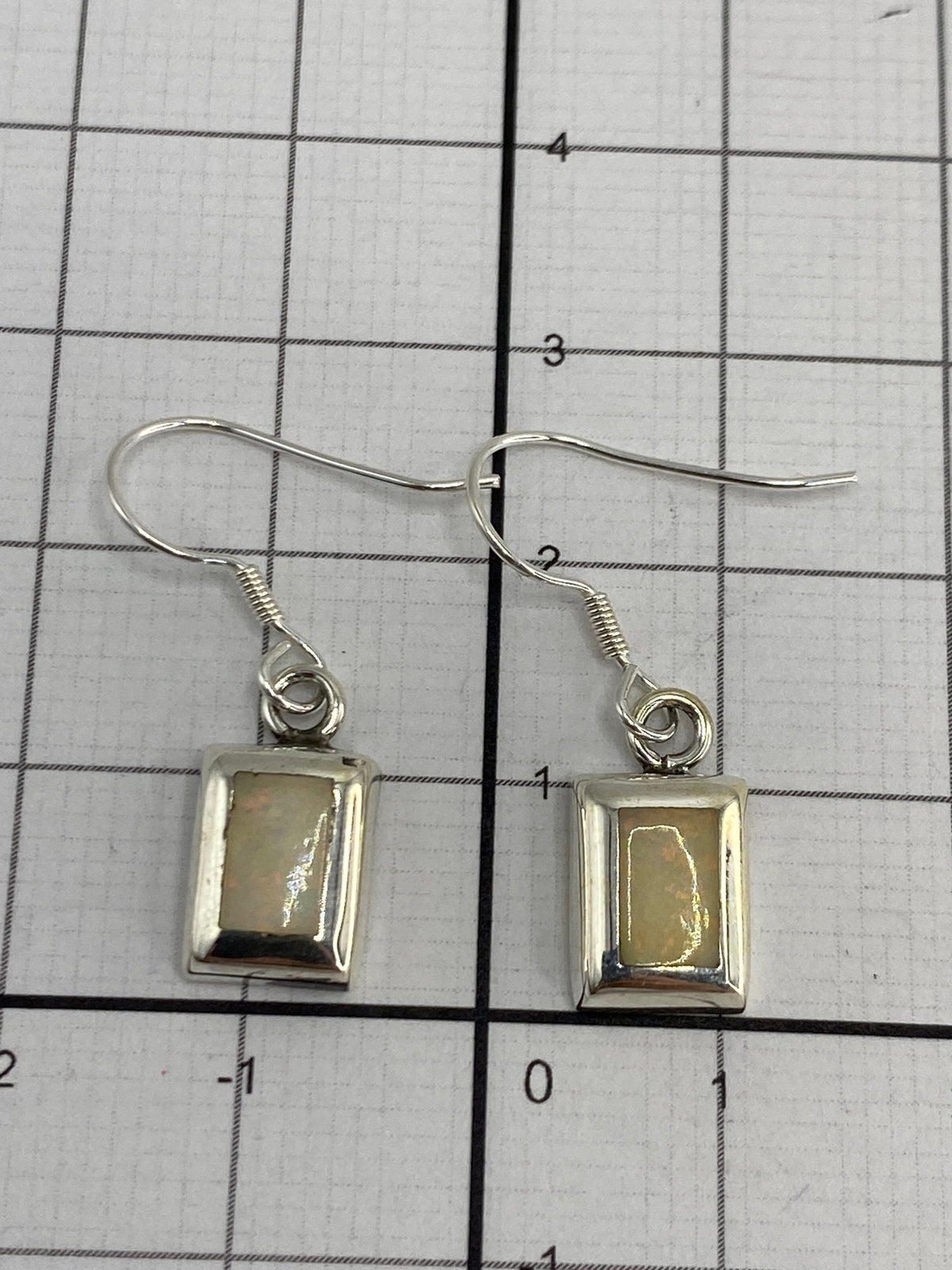 Aretes sobre escala de medición mostrando 2 cm de largo