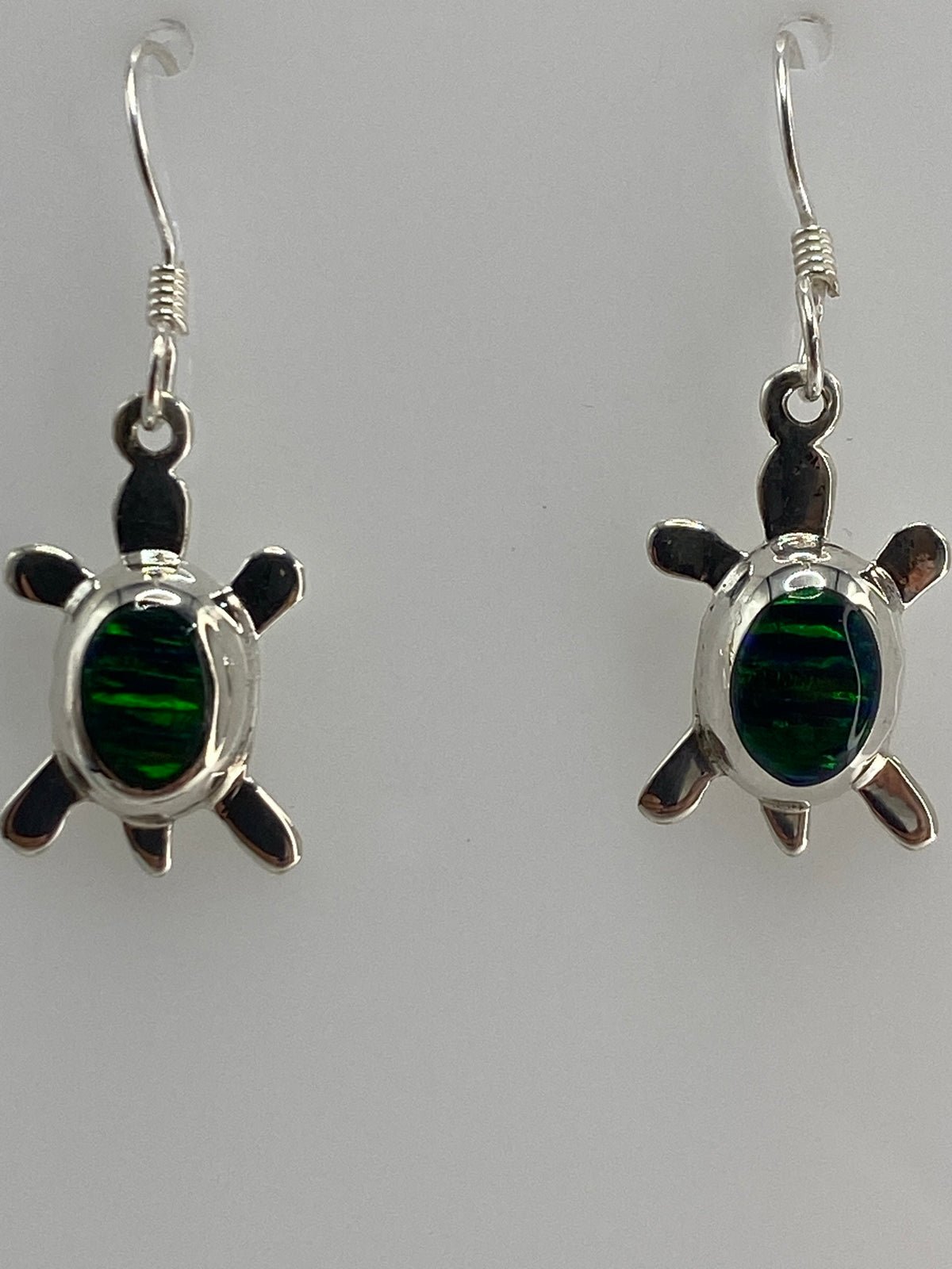 Aretes de tortuga en plata sobre papel milimétrado, largo 2 cm, con hallmark 925