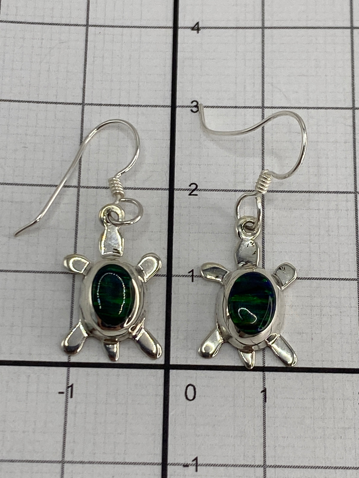 Reverso de los aretes de tortuga de plata mostrando el sello 925 y el engaste a mano