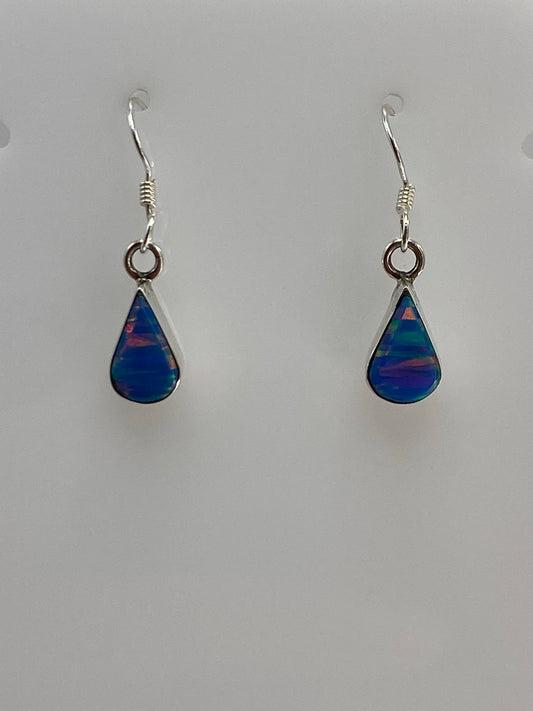 Detalle del ópalo de fuego azul en el arete, mostrando las vetas de color iridiscente
