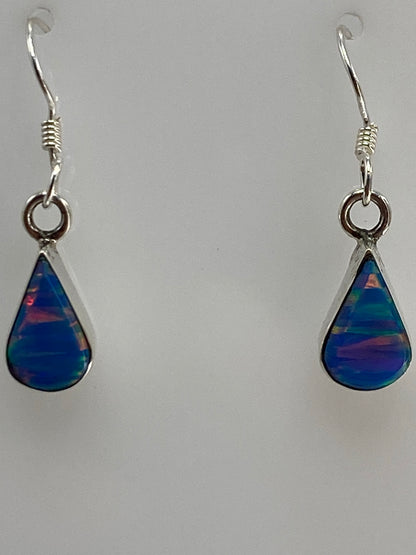 Aretes de plata colgando del gancho, vista frontal del par completo