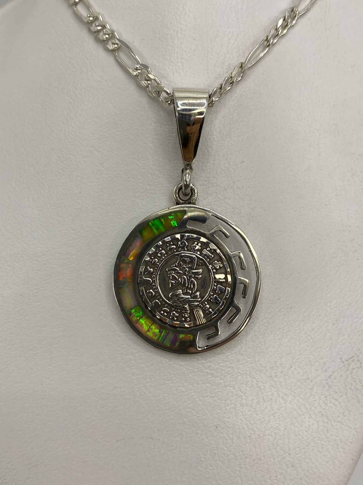 Detalle frontal del Calendario Azteca grabado en plata 950, con ópalo de fuego engastado