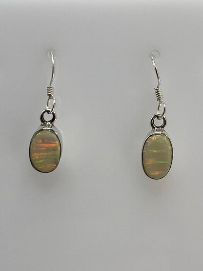 Arete de plata 950 con opalo de fuego mostrando tonos de fuego y oro