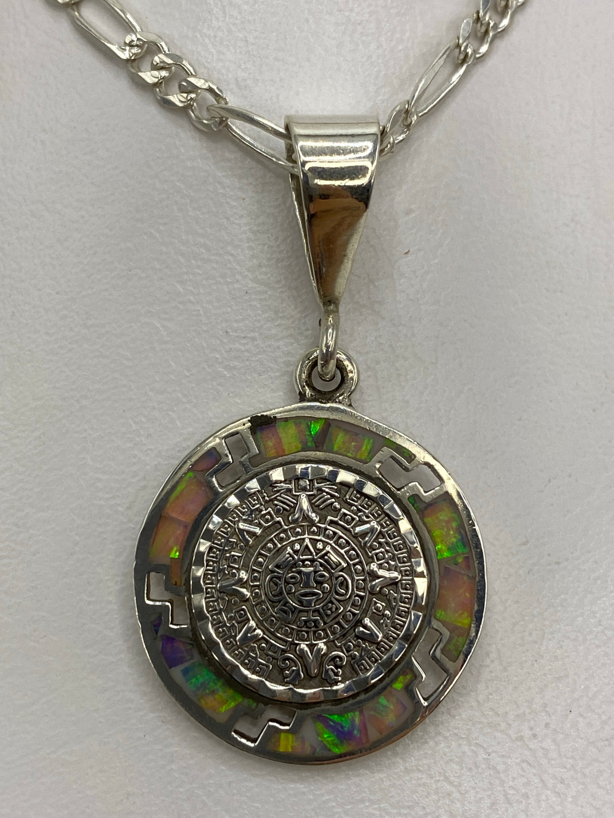 Ópalo de fuego multicolor con tonos verdes y naranjas alrededor del calendario