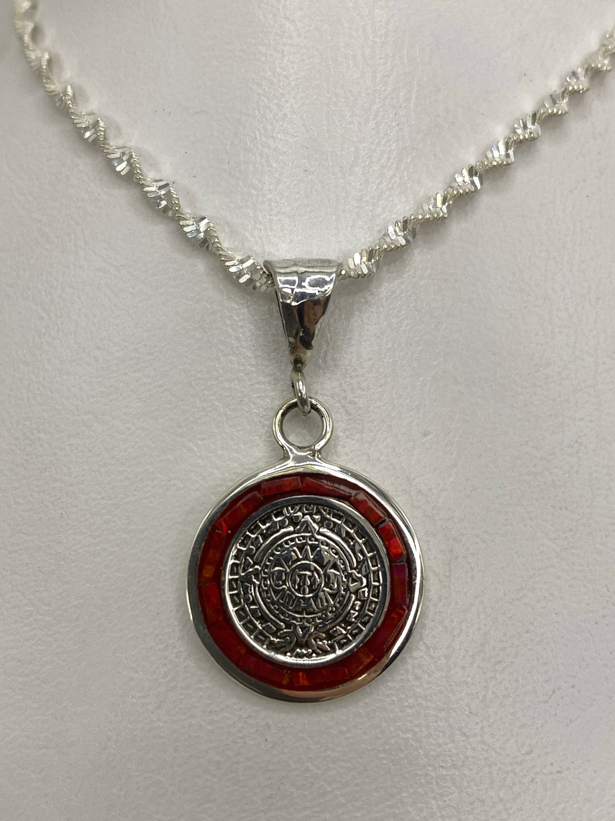 Dije de plata 925 con ópalo de fuego rojo y motivos del calendario azteca colgado de cadena trenzada