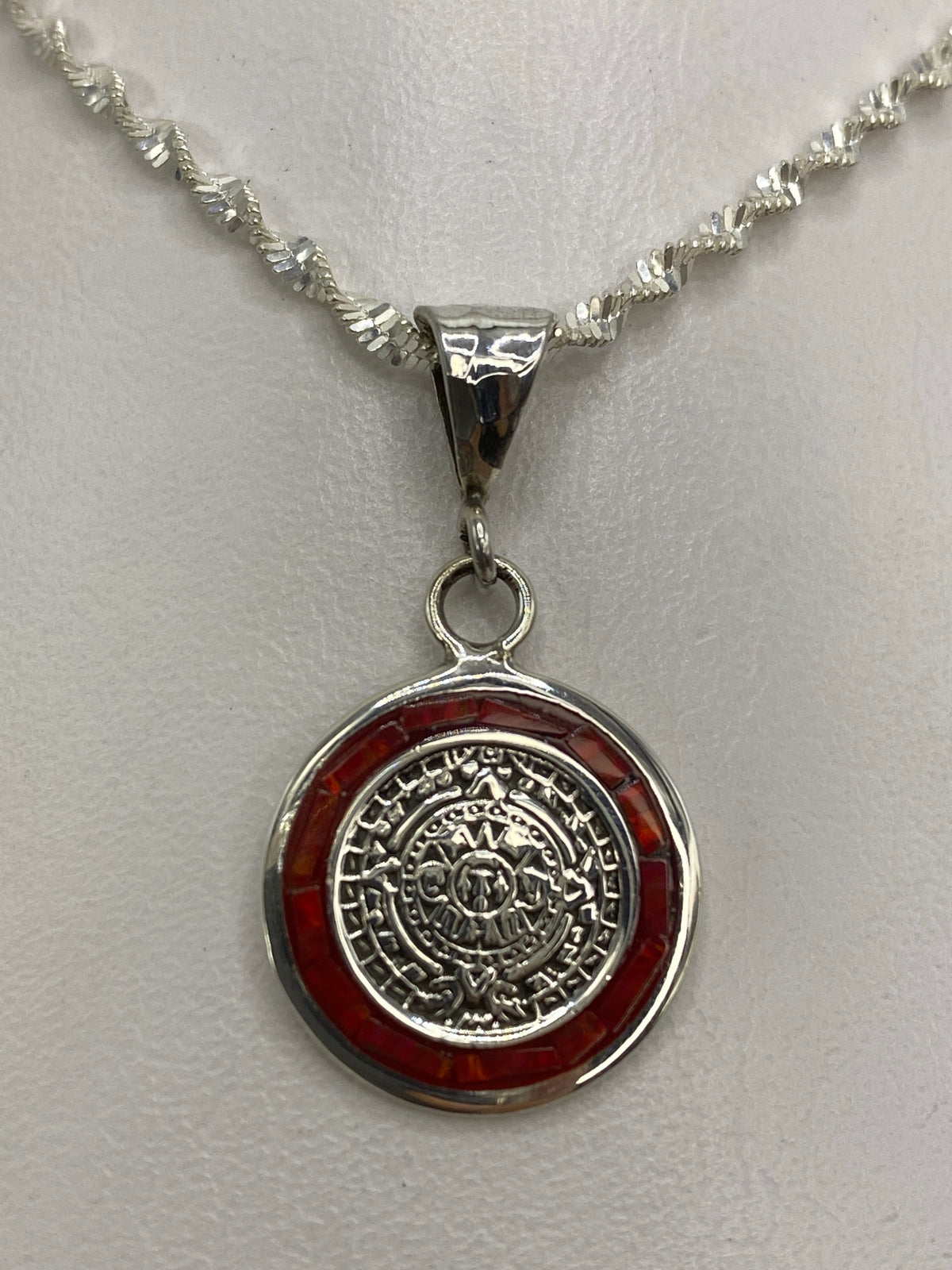 Detalle del ópalo de fuego rojo intenso enmarcado en plata, visto de cerca