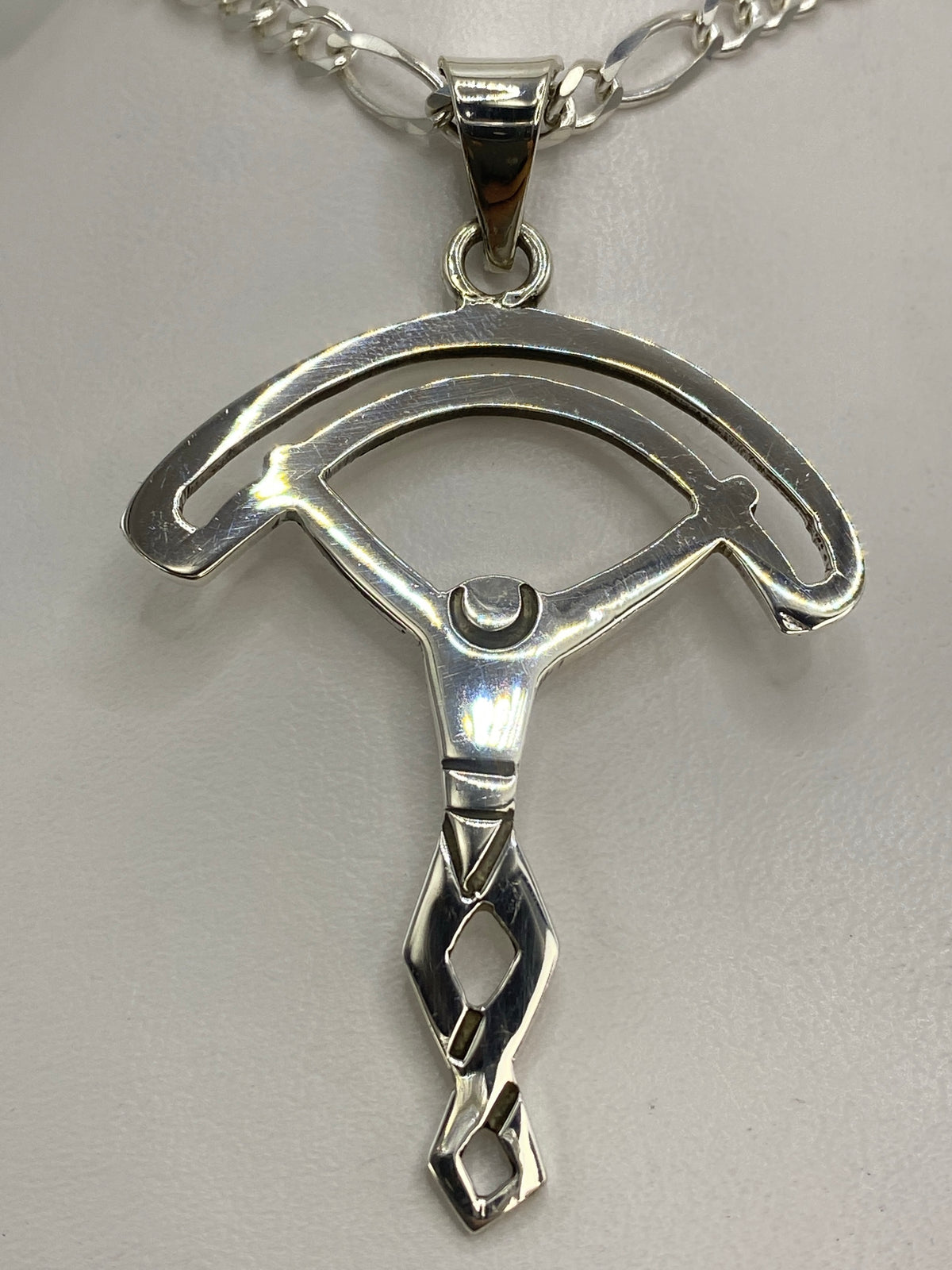 Dije de plata calado en la mano, demostrando el tamaño real y la elegancia minimalista