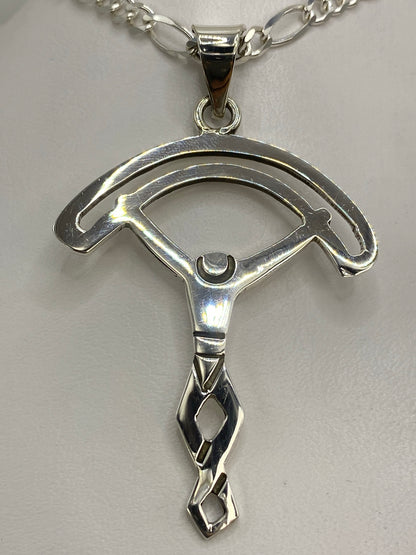 Dije de plata calado en la mano, demostrando el tamaño real y la elegancia minimalista
