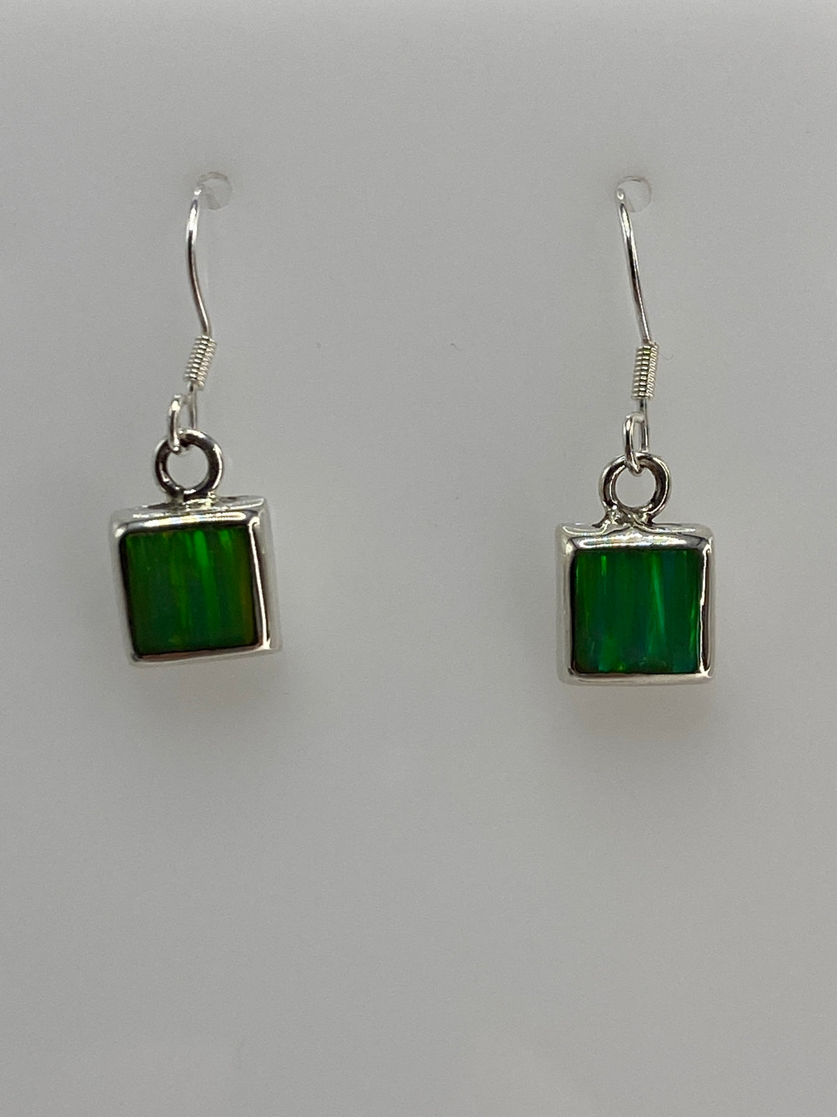 Detalle frontal de un arete mostrando el engaste de la piedra verde en plata