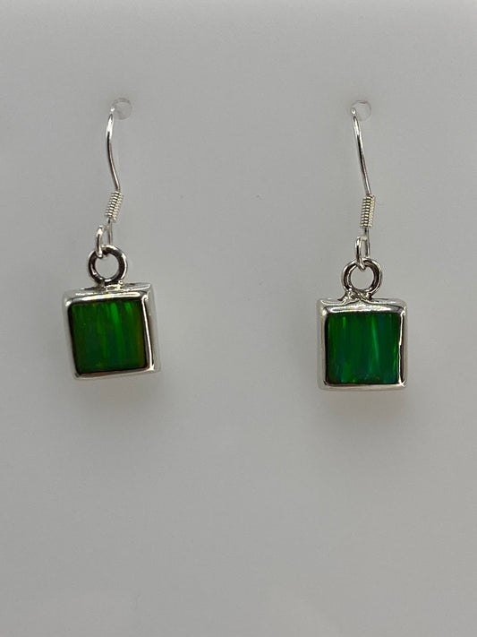 Detalle frontal de un arete mostrando el engaste de la piedra verde en plata