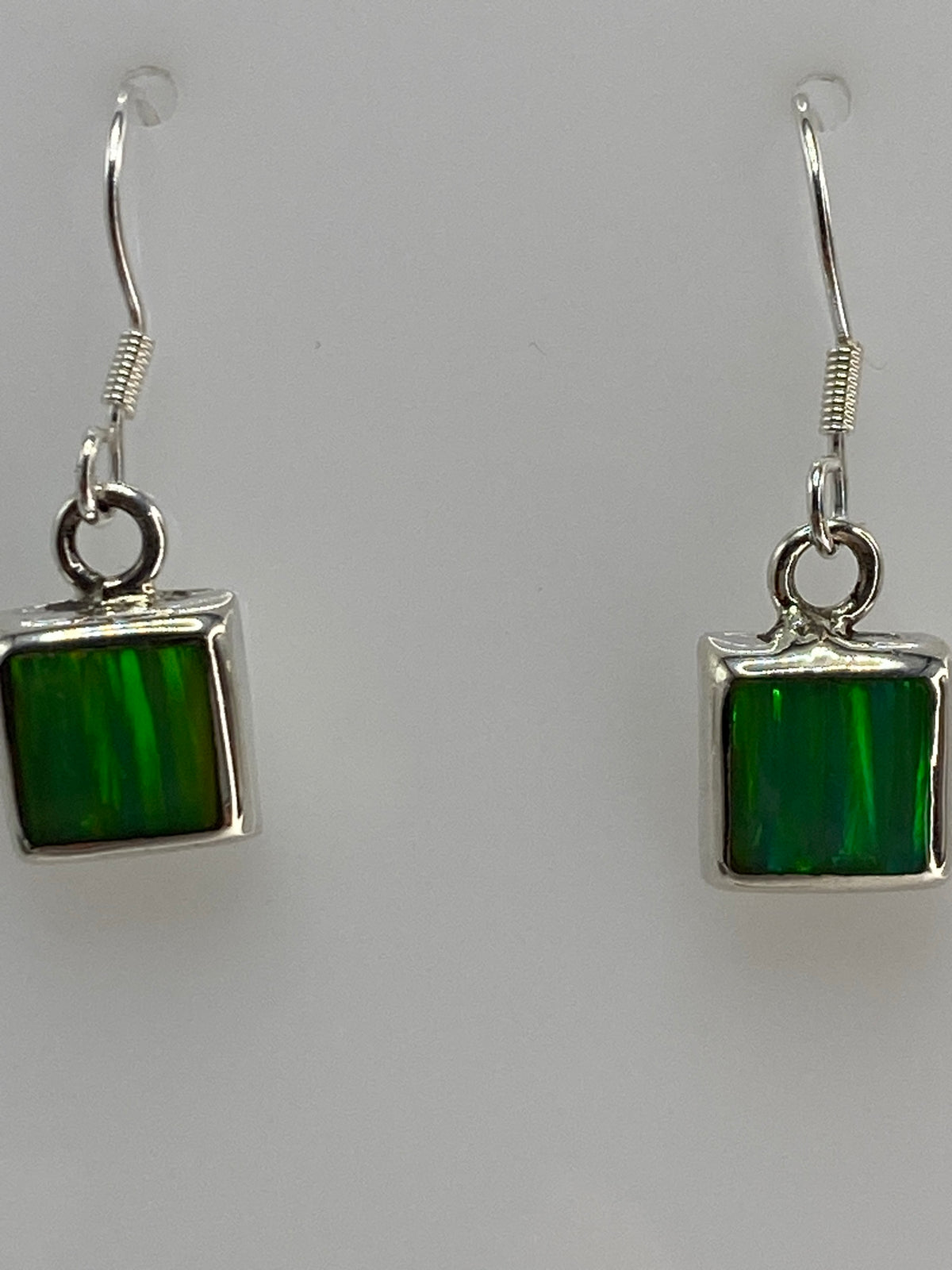 Vista lateral del par de aretes en plata con postes y tuercas de seguridad