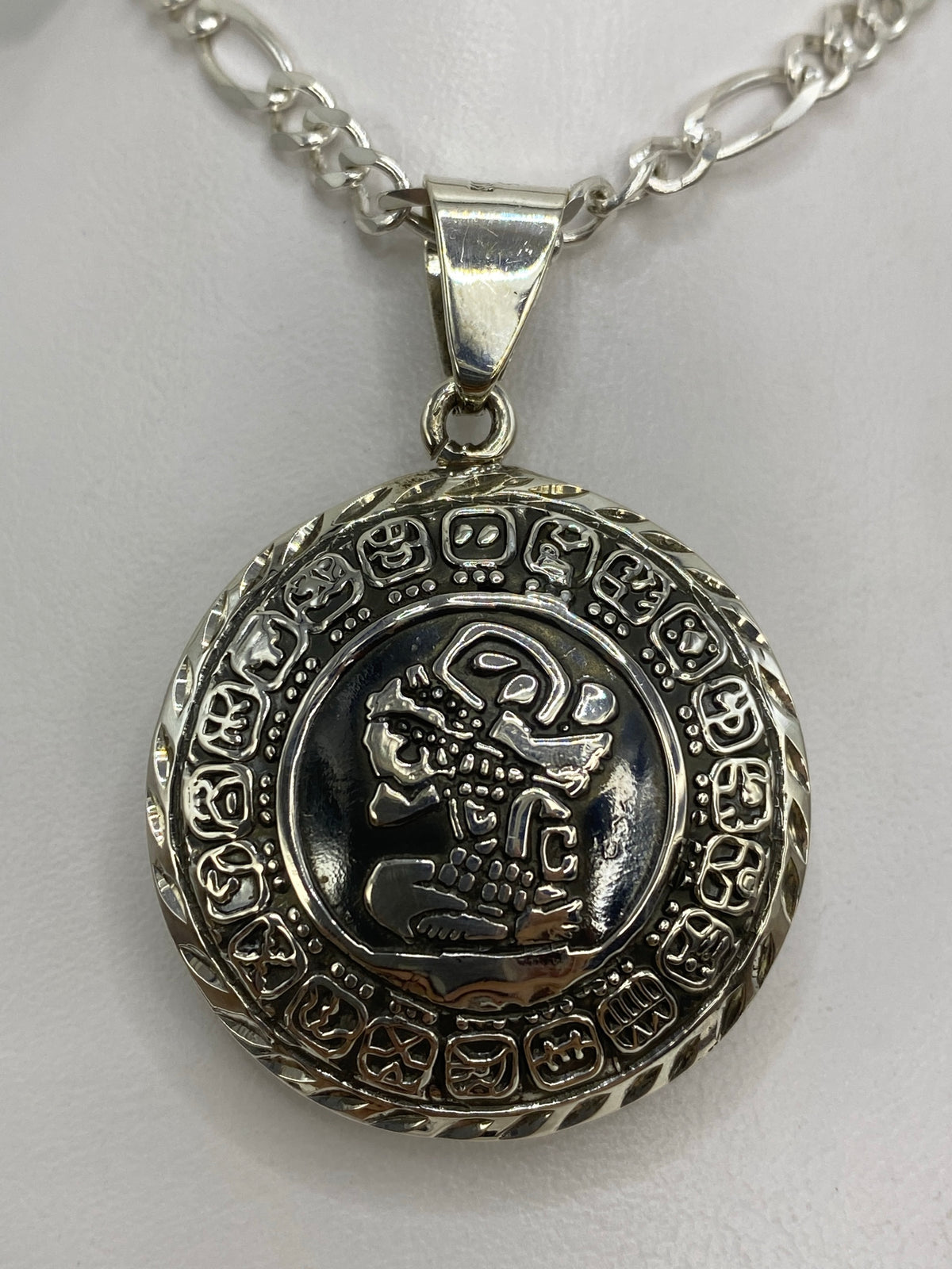 Reverso del dije prehispánico — guerrero de perfil grabado en plata 925