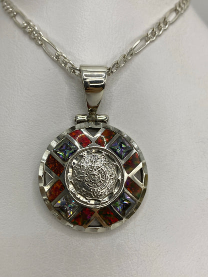 Dije Piedra del Sol en plata 950 con ópal de fuego rojo en el centro, rodeado de detalles prehispánicos