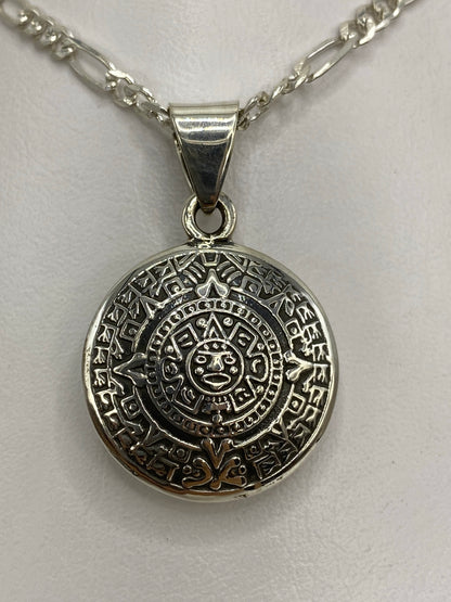 Detalle lateral del dije Calendario Azteca con técnica combinada de fundición y grabado