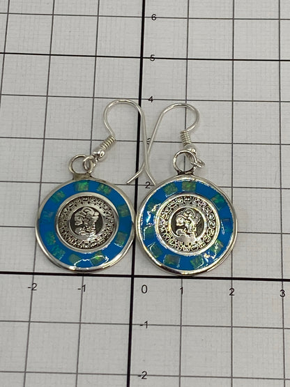 Aretes colgando con la luz reflejada en el ópalo de fuego azul