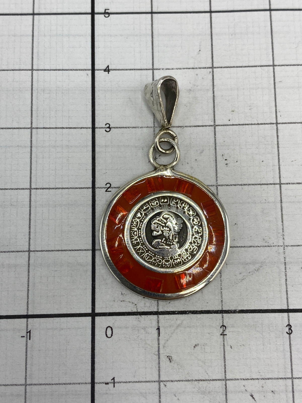 Dije de 3.5 cm sobre regla métrica con cadena de plata retorcida