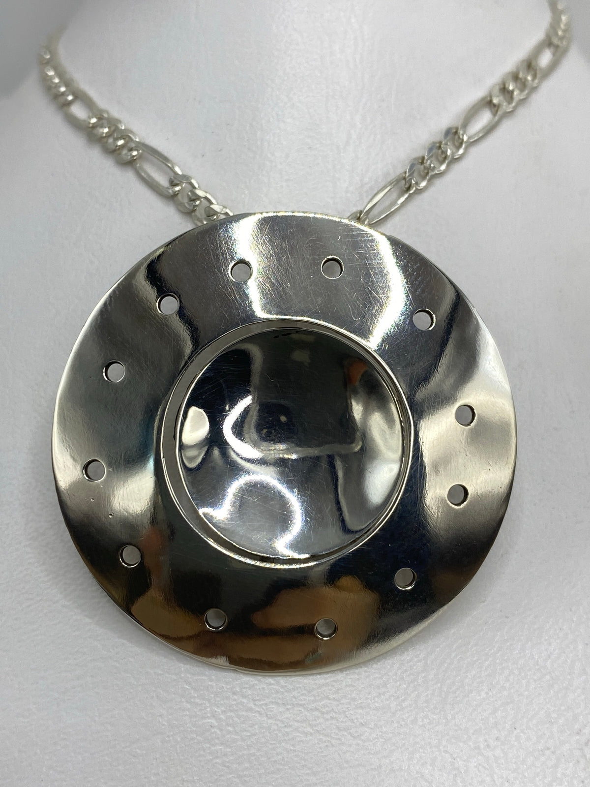 Dije de plata geométrico circular 4 cm en cadena figaro, vista frontal pulida